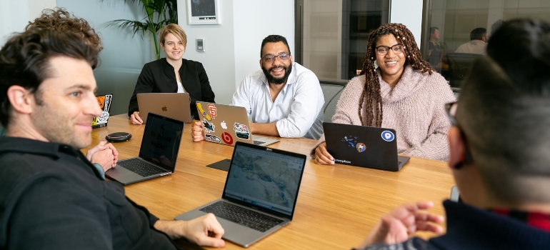 People sitting at a table during a meeting and discussing what to look for in a drug rehab marketing agency 