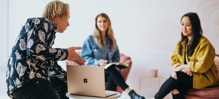 Three people having a business meeting and choosing social media platform for movers
