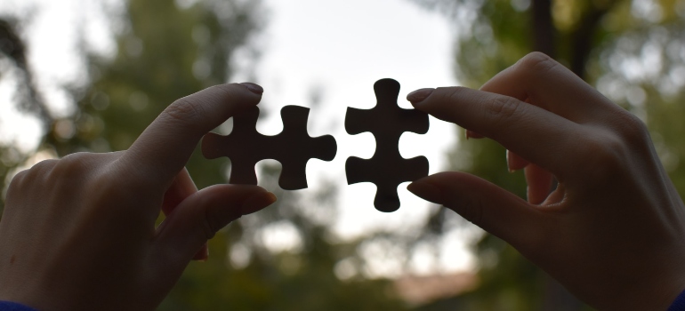 Person putting two puzzle pieces together