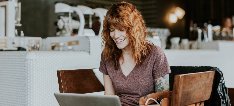 Woman sitting at a coffee shop and using a laptop