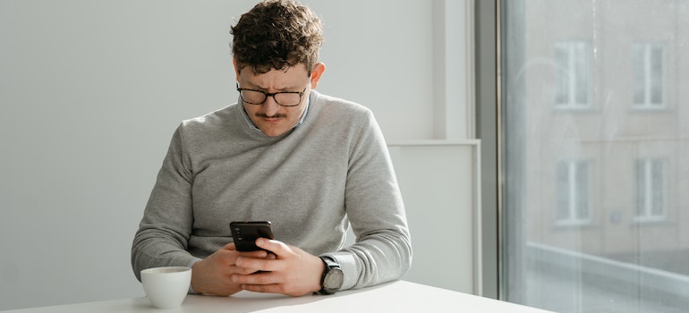 A person using a smartphone looking for social proof while choosing an alcohol addiction center
