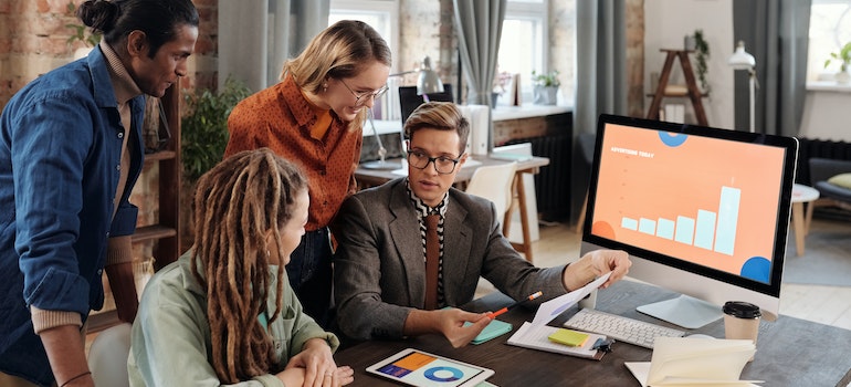A group of coworkers analyzing online presence, which is one of the marketing strategies to increase patient volume