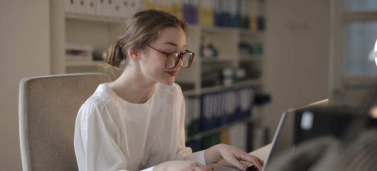 A person writing on a laptop, working on SEO strategies to ensure family involvement in alcohol rehab marketing