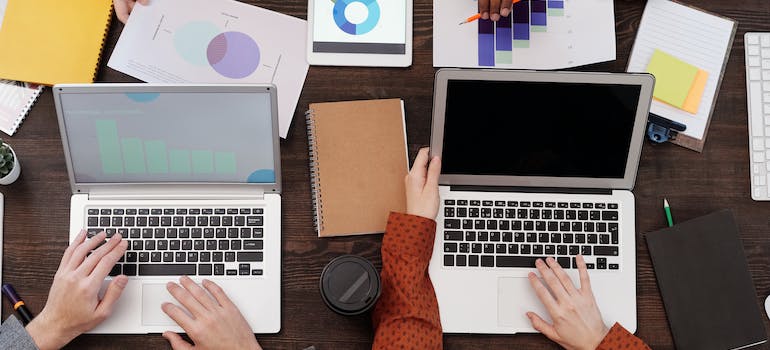 Two people using their laptops to measure the the impact of their email marketing campaigns