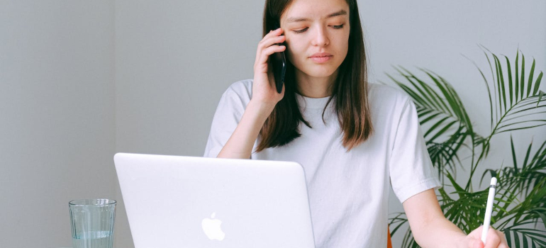 a person is on the phone while writing something down
