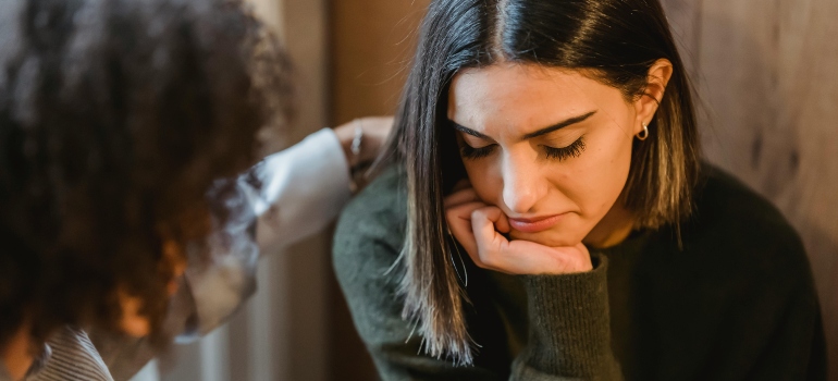 A person comforting a sad woman
