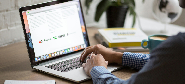A professional working on a laptop with an article about email marketing open on the screen, implementing marketing strategies for telehealth behavioral services.