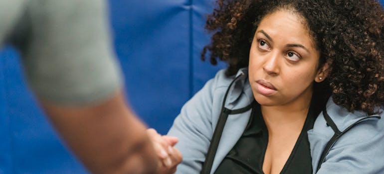 a person reaching out to help a woman