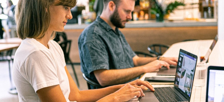 a man and a woman working on their laptops