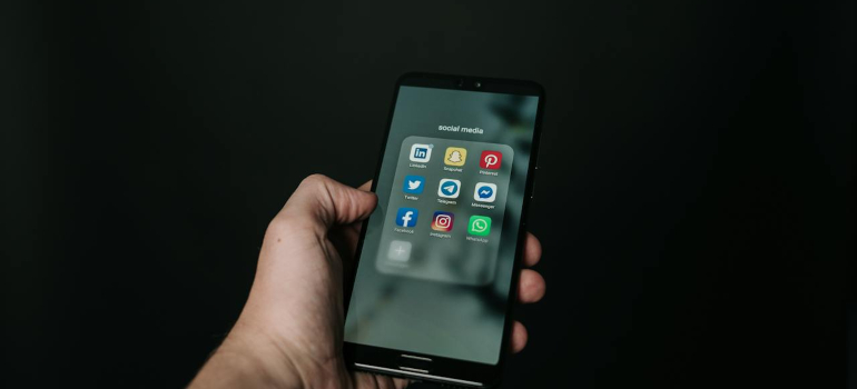 a person holding a phone with social media on it