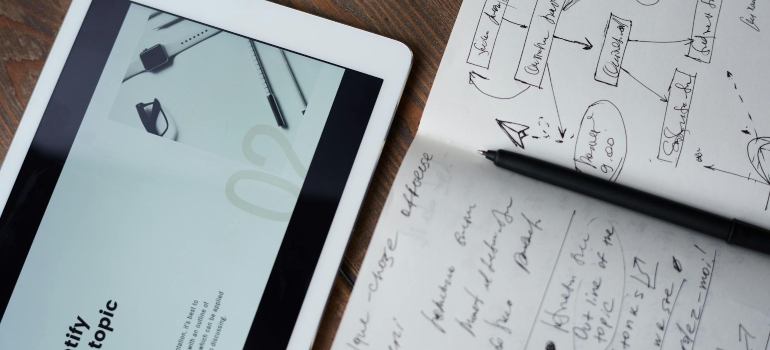 a tablet and a notebook on the desk 