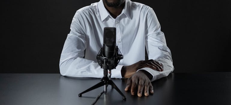 A person sitting in front of a microphone on a table