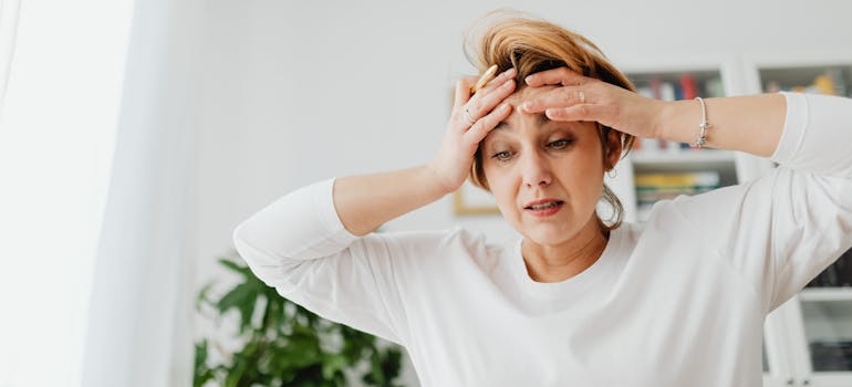 A person with their hands on their forehead, worrying about finances due to the upcoming holidays