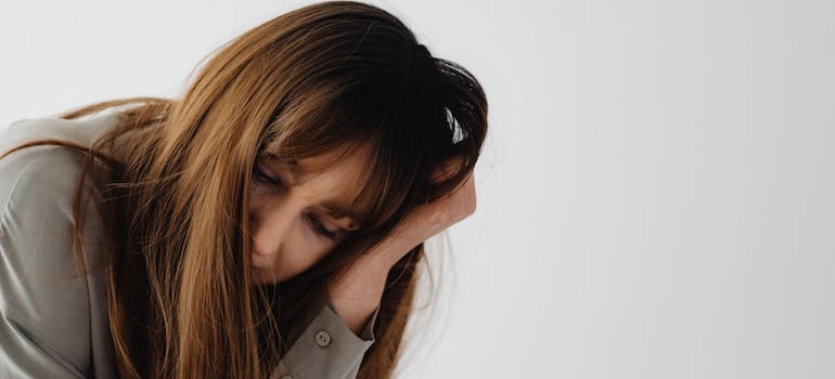 A sad person holding their head