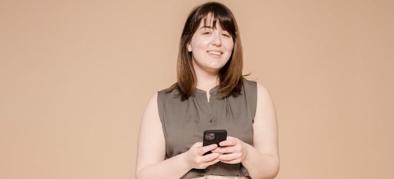 A smiling person using their smartphone