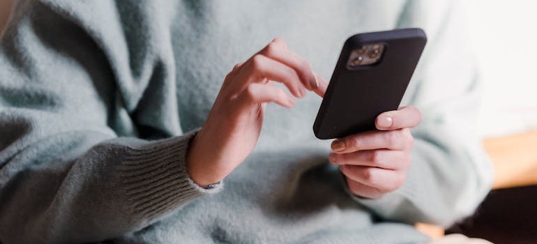 A person using their smartphone to shop online, which is a common behavior and something to be aware while working on PPC ads during Dubai's busy shopping seasons