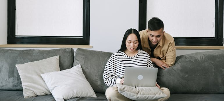 Two people using a laptop to look for information about rehab insurance