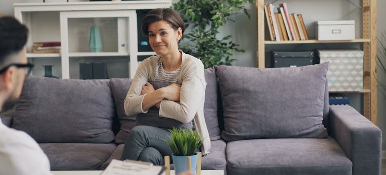 A person sitting on a couch and talking to a therapist