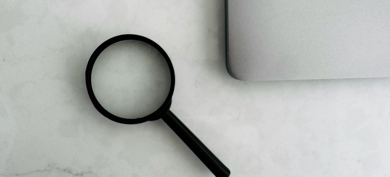 Magnifying glass next to a laptop
