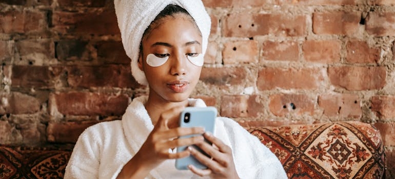 A person in a robe using their phone to look for medspa facilities