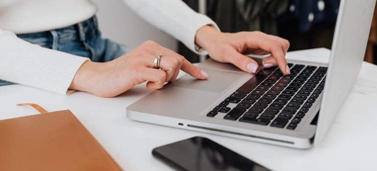 A person exploring rehab insurance pages of an addiction center using a laptop