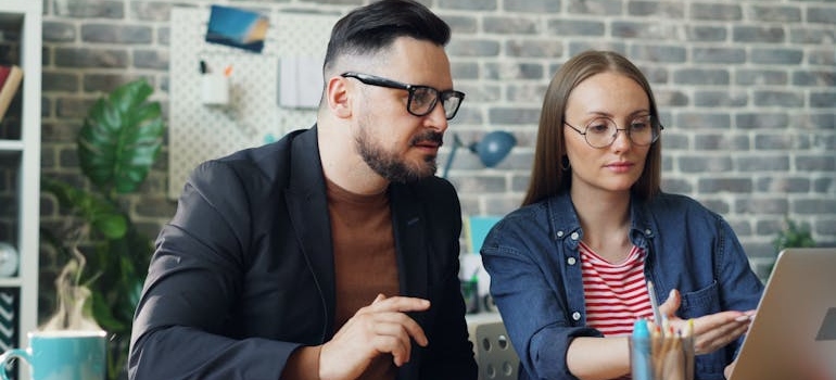 Two colleagues looking at a laptop while discussing how call tracking can be HIPAA-compliant