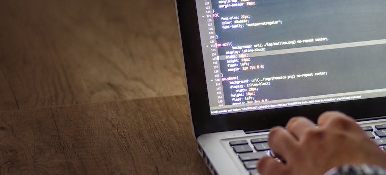 A person using a laptop to design a website after learning how web design affects conversion rates