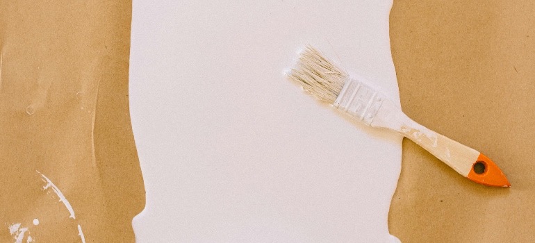 Paintbrush and spilled white paint