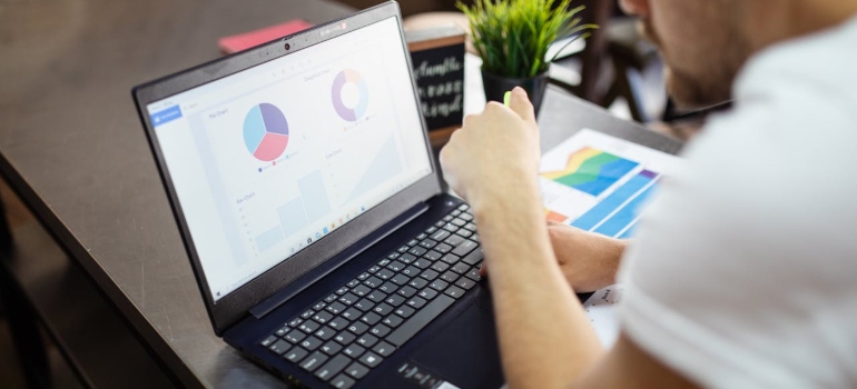 a man looking at some charts on his laptop