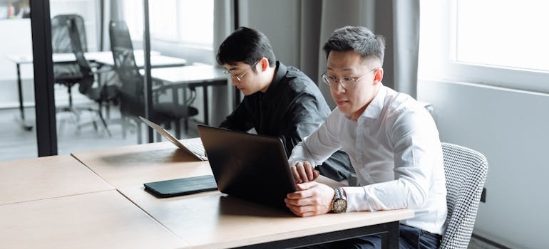 Two colleagues checking sites for company reviews